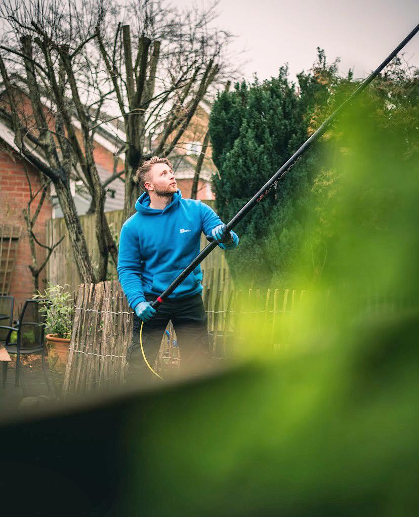 JE Window Cleaning team member cleaning windows
